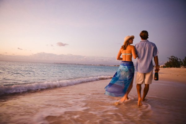 Couple Walking On Beach At Sunset